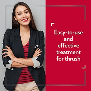 Smiling young woman wearing smart clothes with her arms crossed, happy after Canesten treatment, with the caption An easy-to-use and effective treatment for thrush