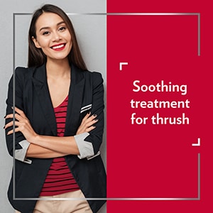 Smiling young woman wearing smart clothes with her arms crossed, happy after Canesten treatment, with the caption ‘’ Soothing treatment for thrush’’